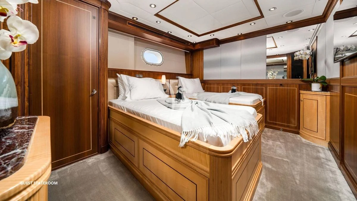 a room with a bed and a wood cabinet aboard BLACK SHEEP Yacht for Sale