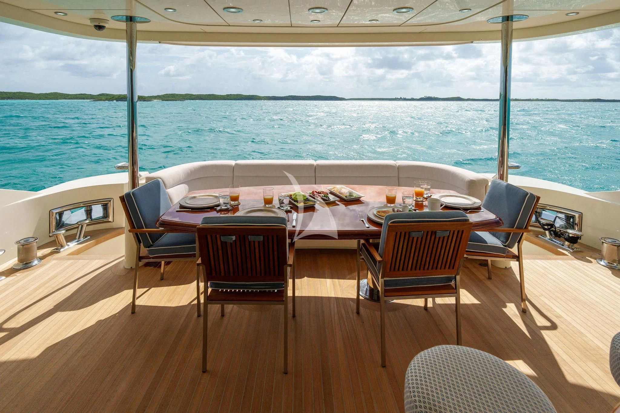 a table set for a meal on a deck overlooking the ocean aboard BLACK SHEEP Yacht for Sale