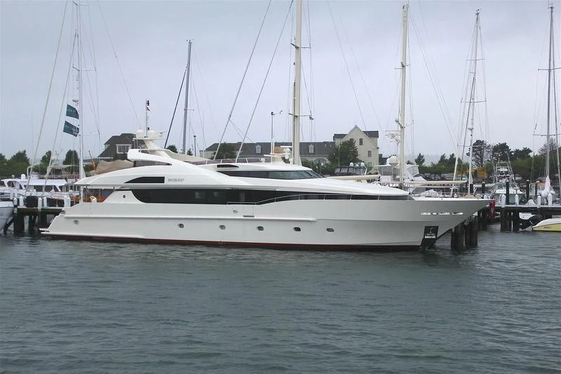a white yacht in a harbor aboard BLACK SHEEP Yacht for Sale