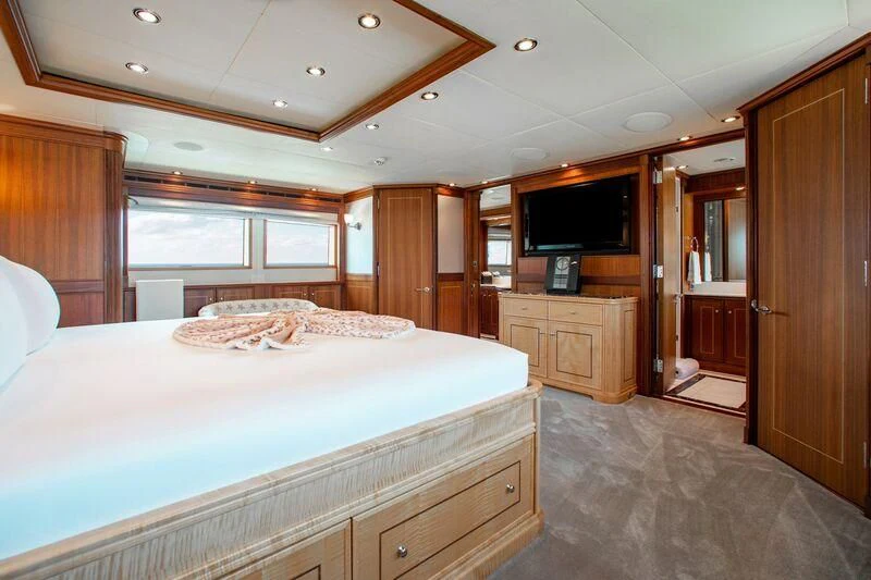 a bedroom with a bed and a television aboard BLACK SHEEP Yacht for Sale