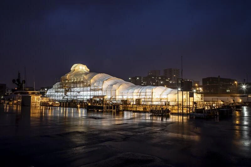 a large white building with a dome roof and a bridge over water at night aboard ROYAL ROMANCE Yacht for Sale