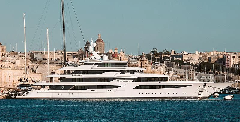 a large white boat in a harbor aboard ROYAL ROMANCE Yacht for Sale