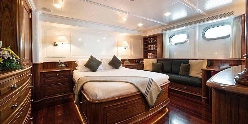 a bedroom with a bed and a couch aboard V6 Yacht for Sale