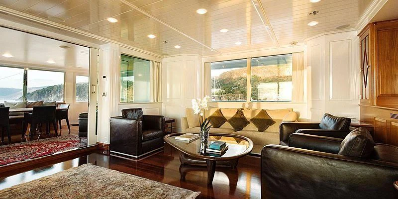 a living room with leather couches and a coffee table aboard V6 Yacht for Sale
