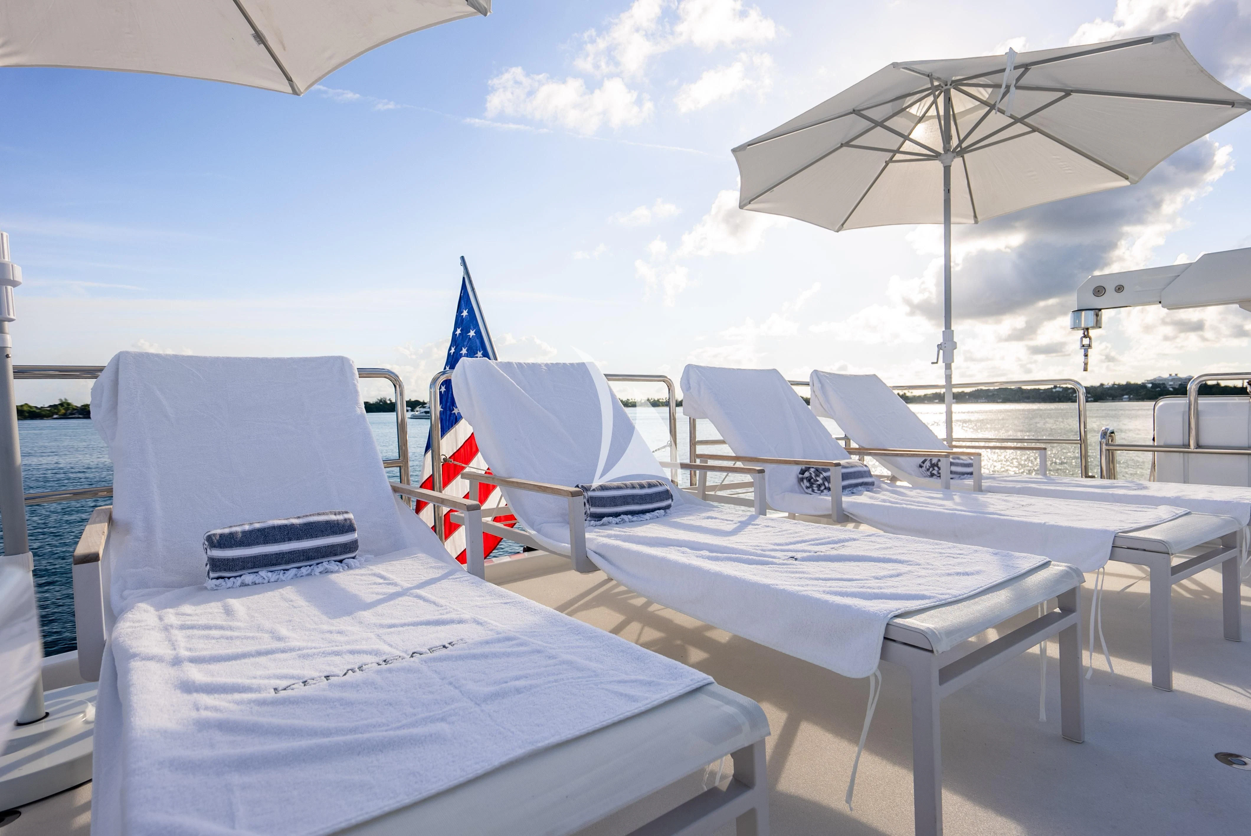a group of chairs and tables on a beach aboard KEMOSABE Yacht for Charter