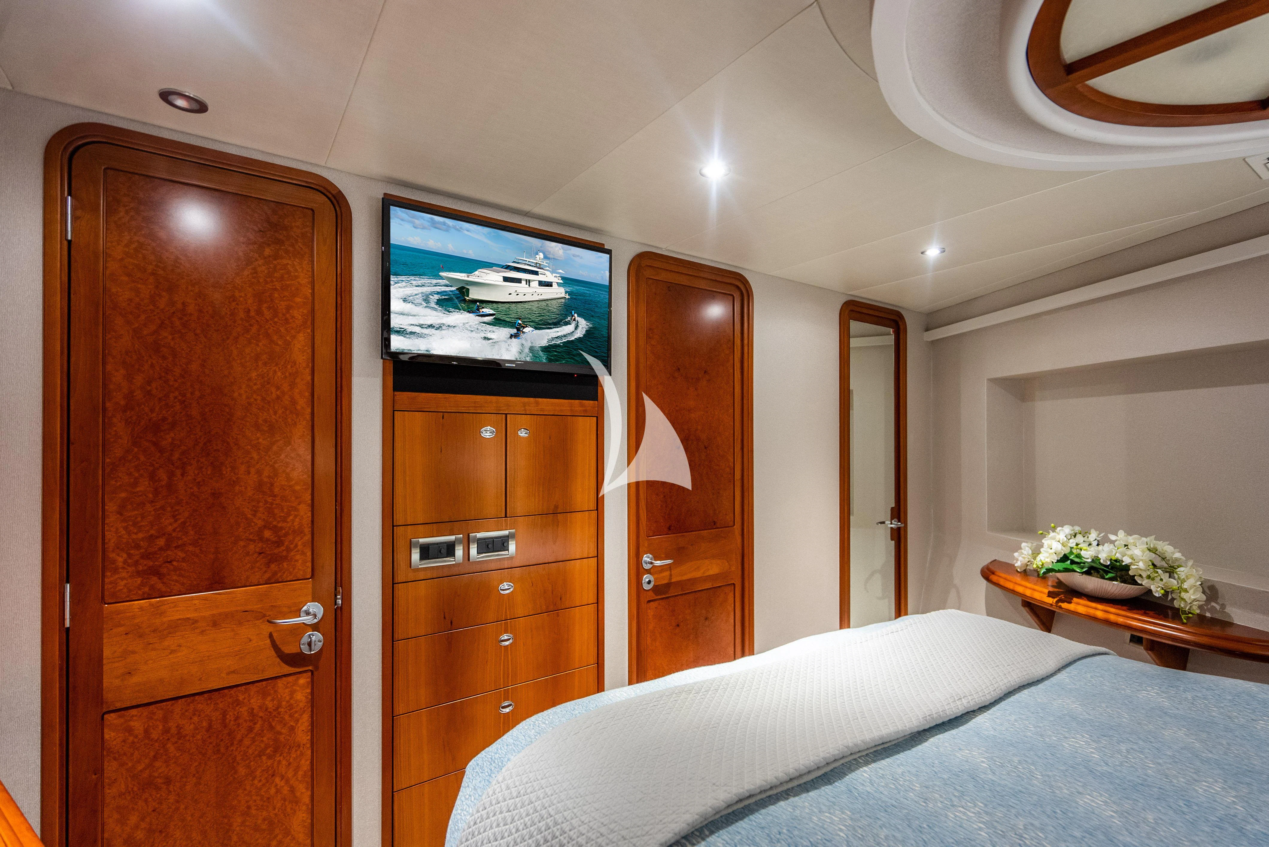 a bedroom with a television and a dresser aboard KEMOSABE Yacht for Charter