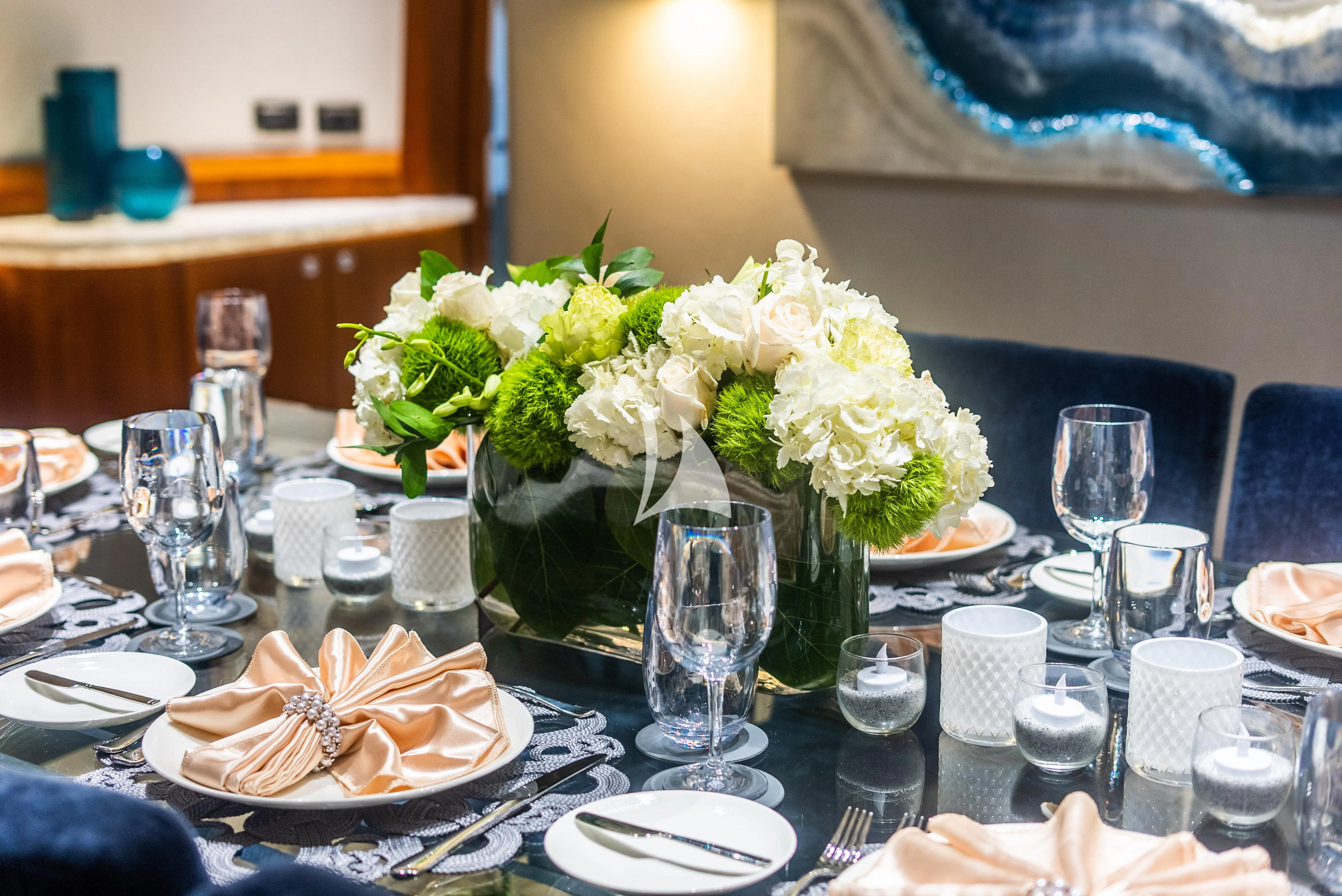 a table with plates and glasses aboard KEMOSABE Yacht for Charter