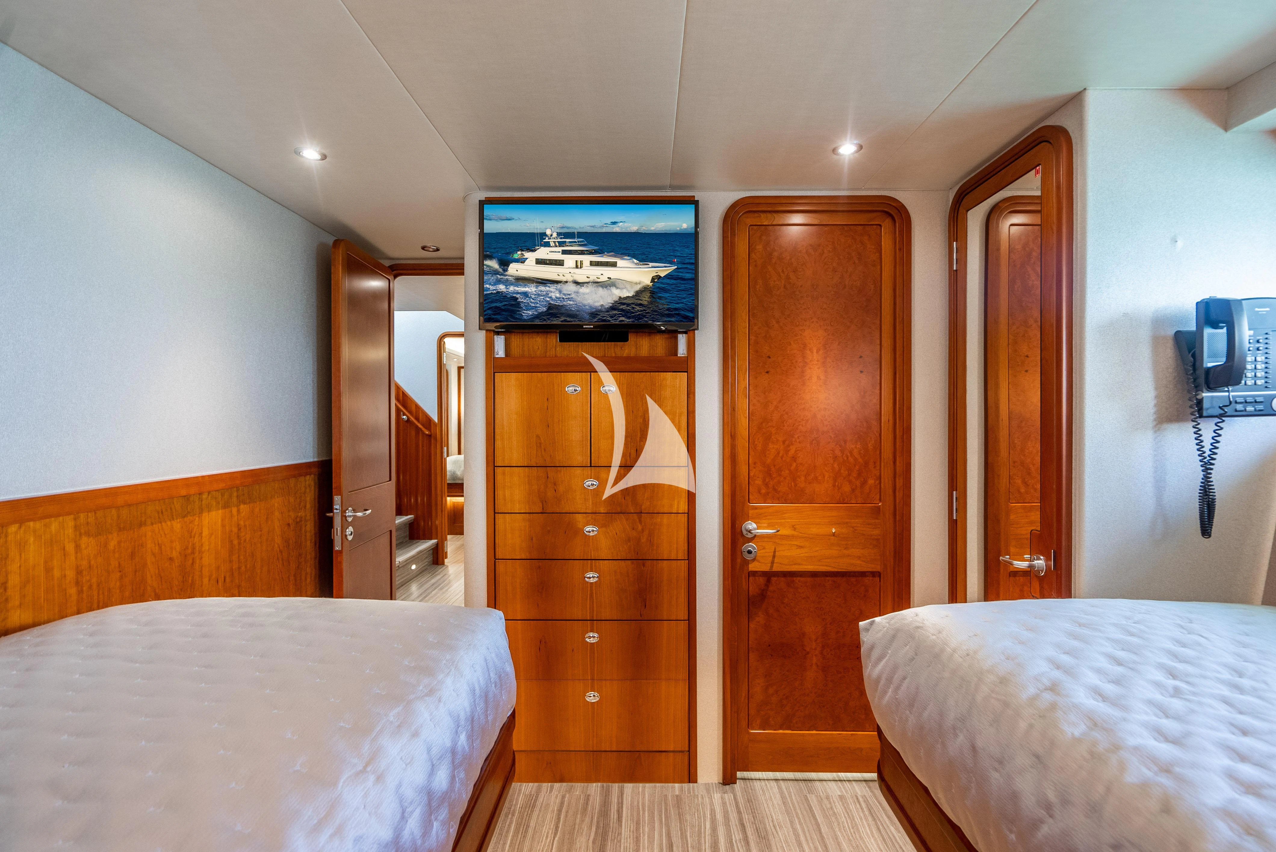 a bedroom with a tv and a bed aboard KEMOSABE Yacht for Charter