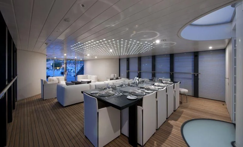 a large room with a table and chairs aboard OCEAN SAPPHIRE Yacht for Sale
