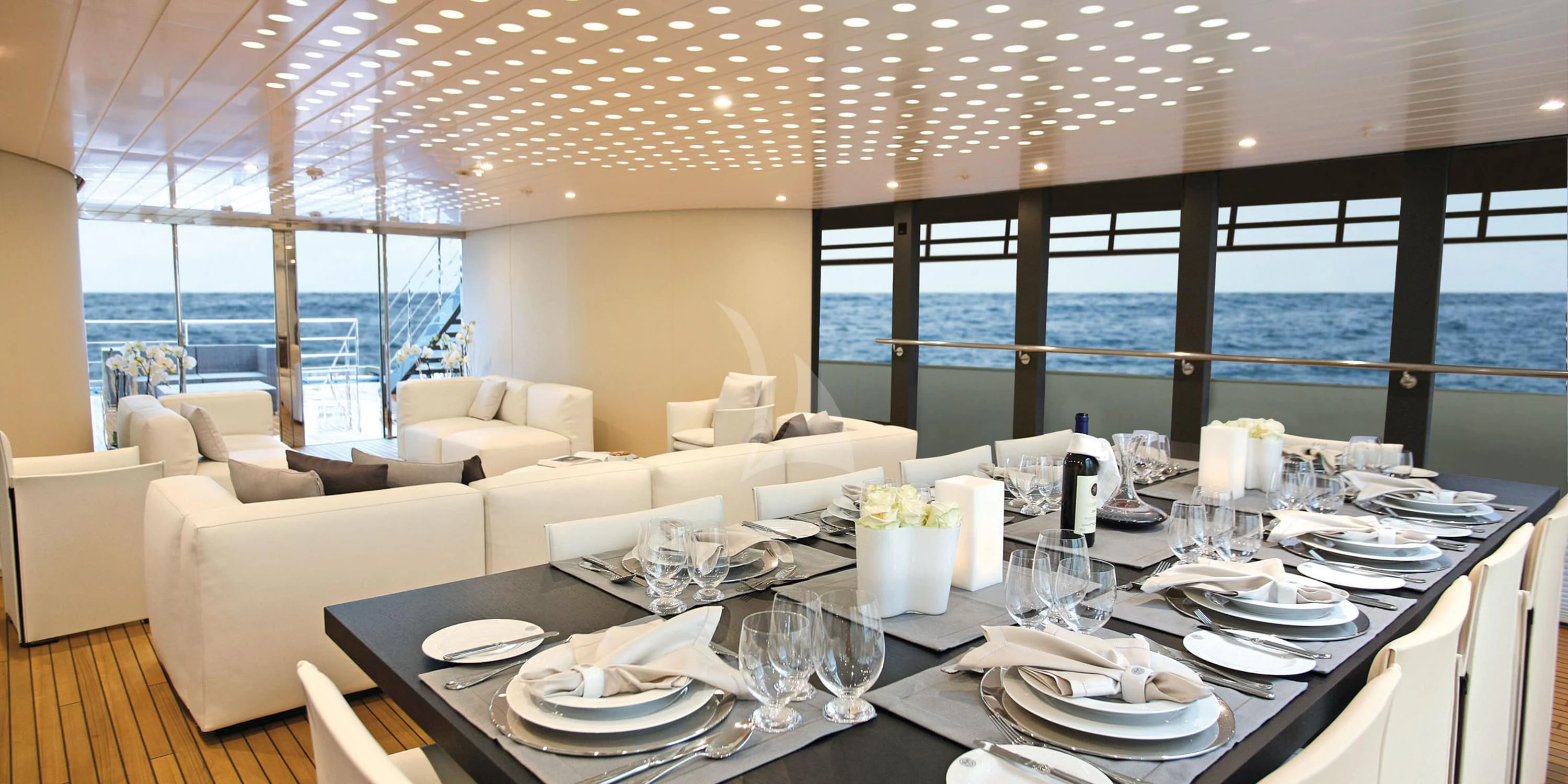 a large dining table with plates and chairs aboard OCEAN SAPPHIRE Yacht for Sale