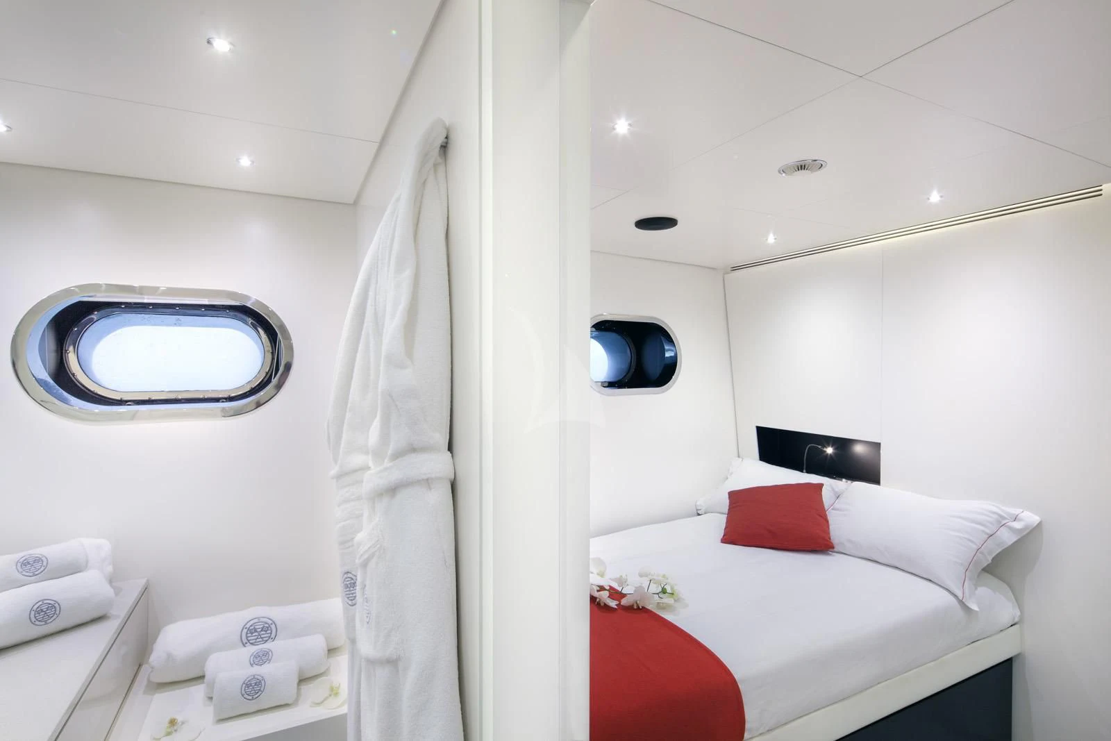 a bed with a white sheet and a red pillow aboard OCEAN SAPPHIRE Yacht for Sale