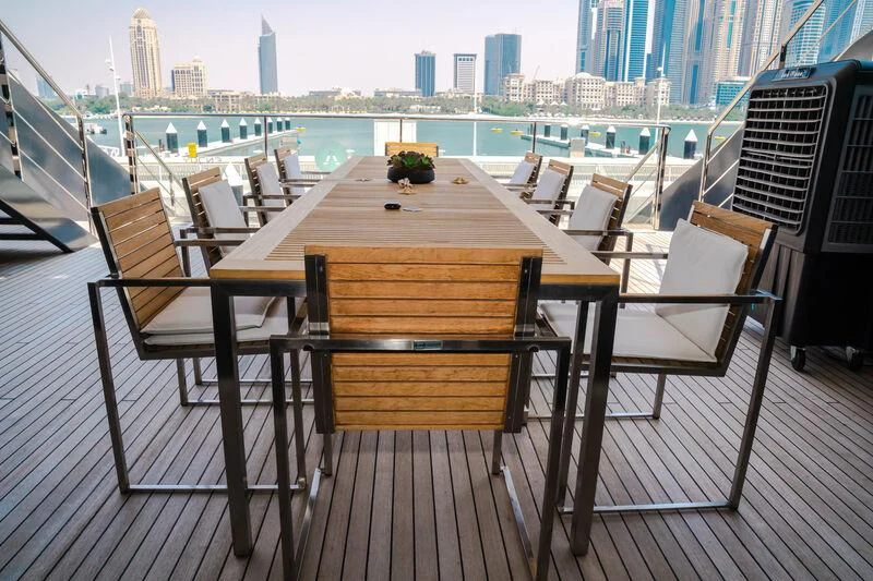 a table and chairs on a deck overlooking a city aboard OCEAN SAPPHIRE Yacht for Sale