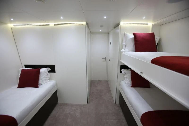 a room with beds and a door aboard OCEAN SAPPHIRE Yacht for Sale