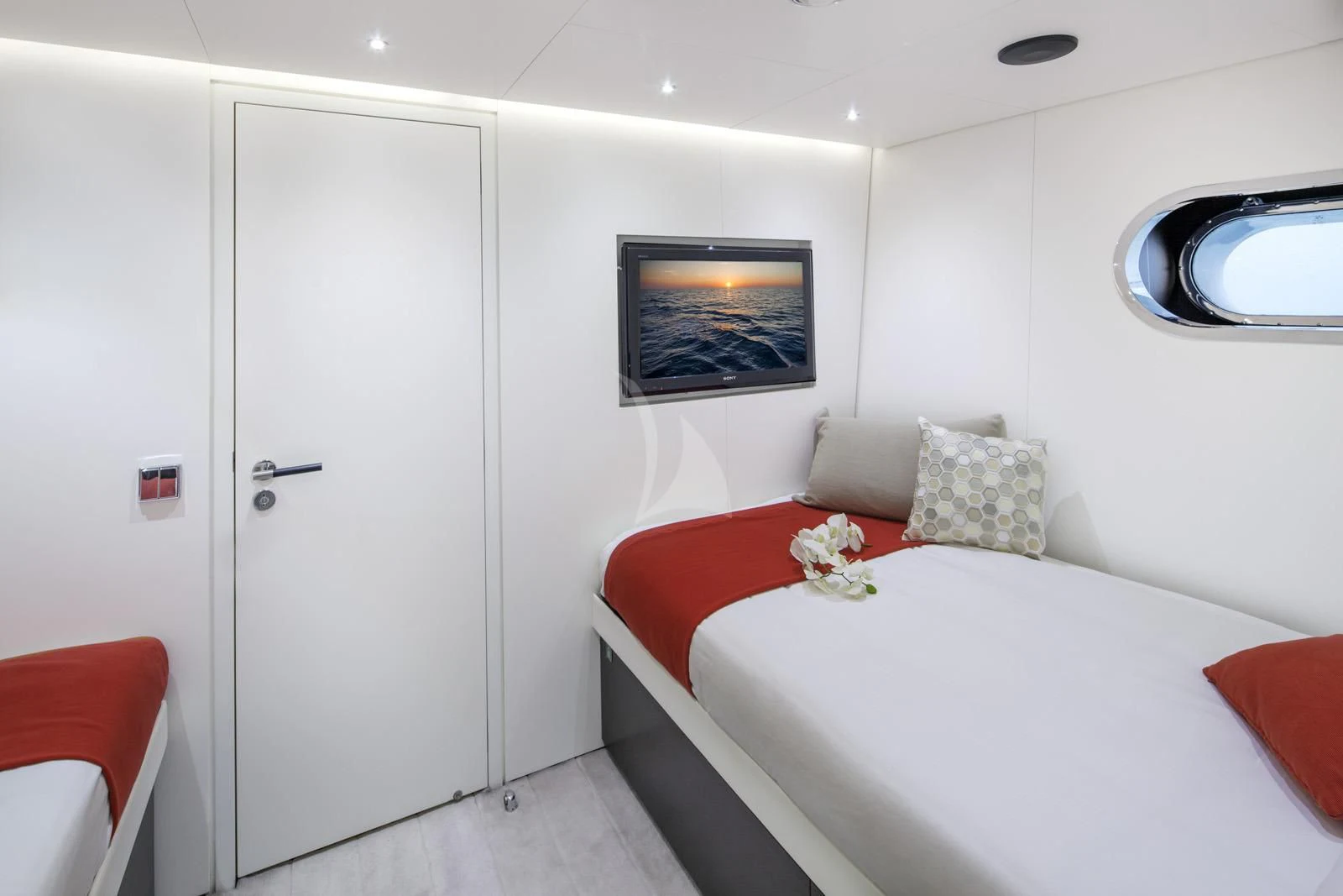 a room with a bed and a white door aboard OCEAN SAPPHIRE Yacht for Sale