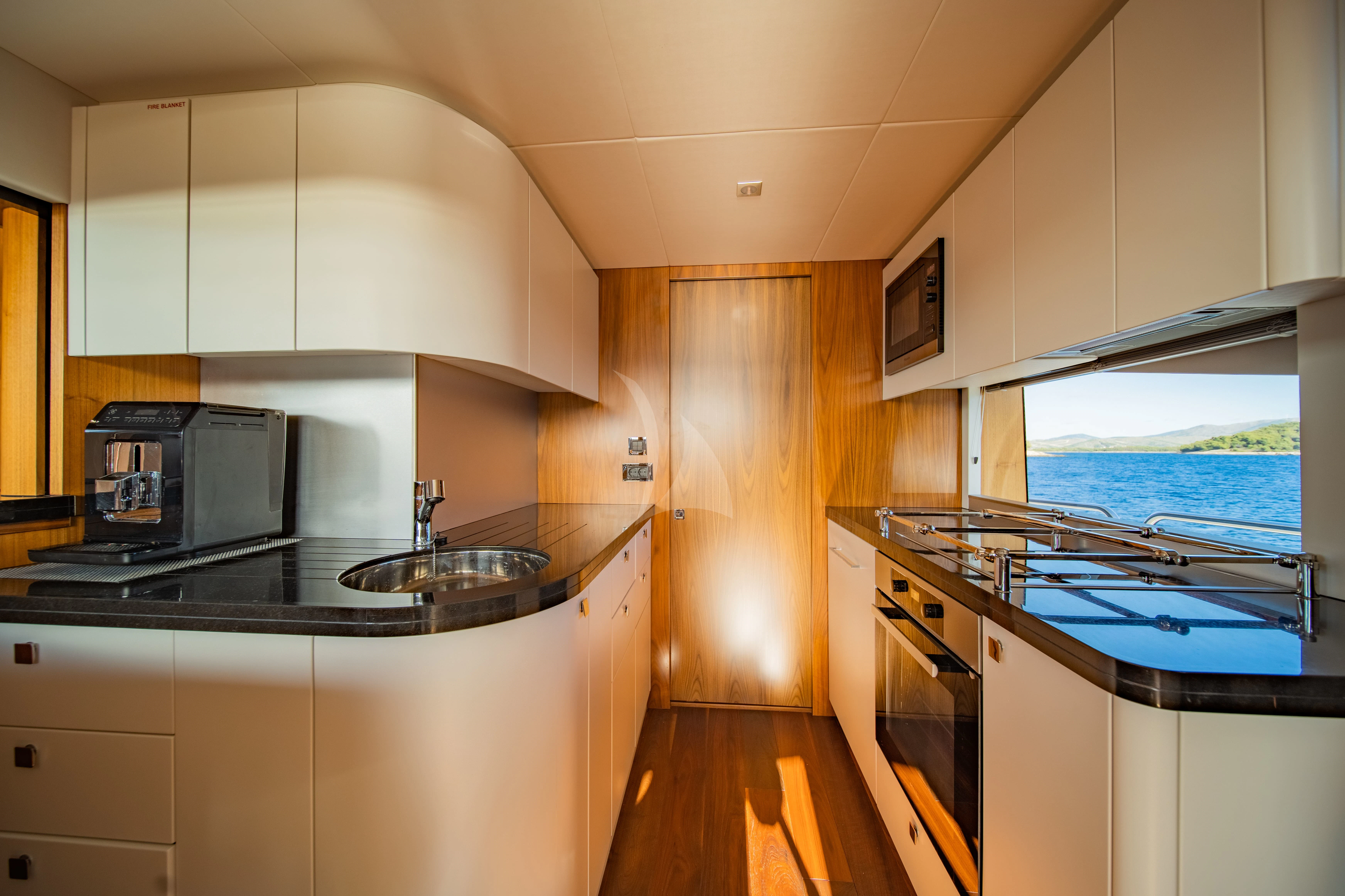 a kitchen with a sink and microwave aboard BLACK MAMBA Yacht for Charter