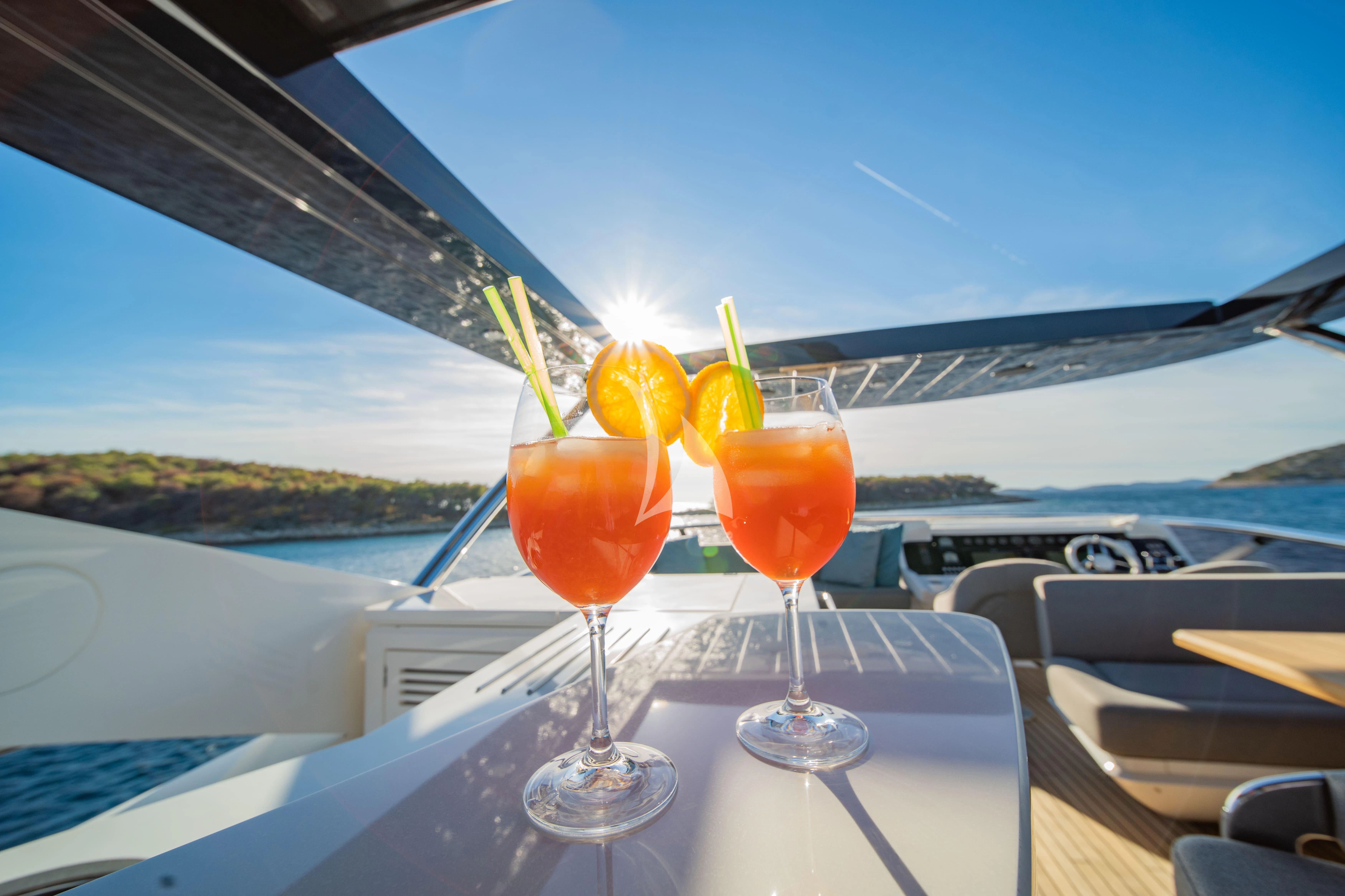a couple of glasses with drinks on a table aboard BLACK MAMBA Yacht for Charter