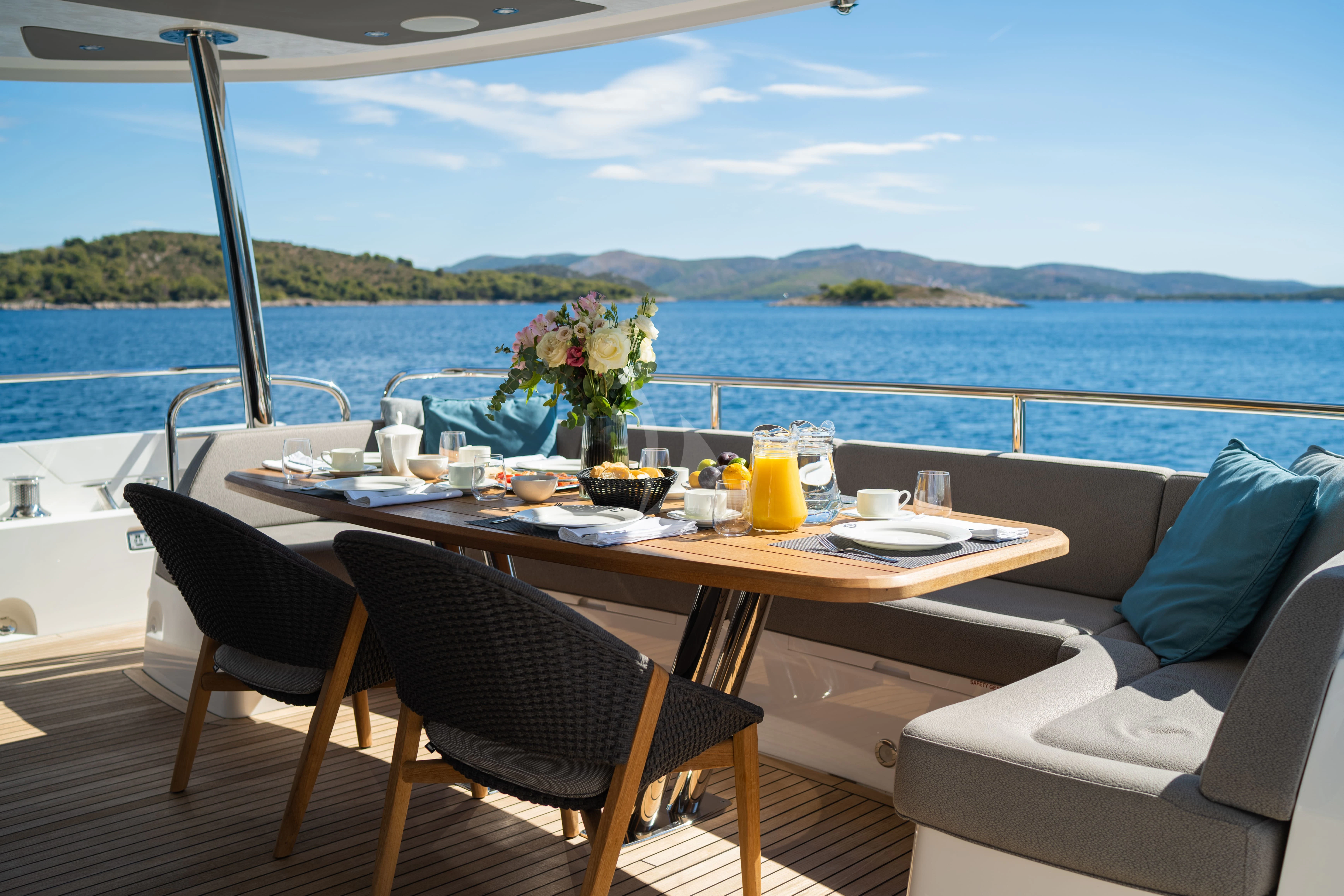 a table with chairs and a view of the ocean aboard BLACK MAMBA Yacht for Charter