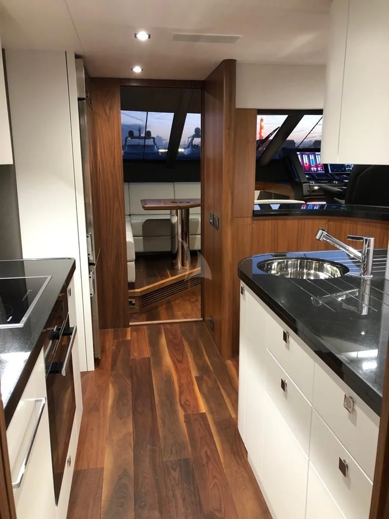 a kitchen with a wood floor aboard BLACK MAMBA Yacht for Charter