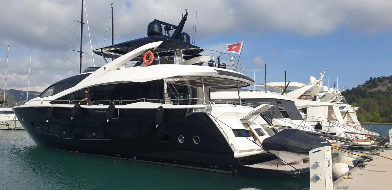 a large boat docked at a dock aboard BLACK MAMBA Yacht for Charter