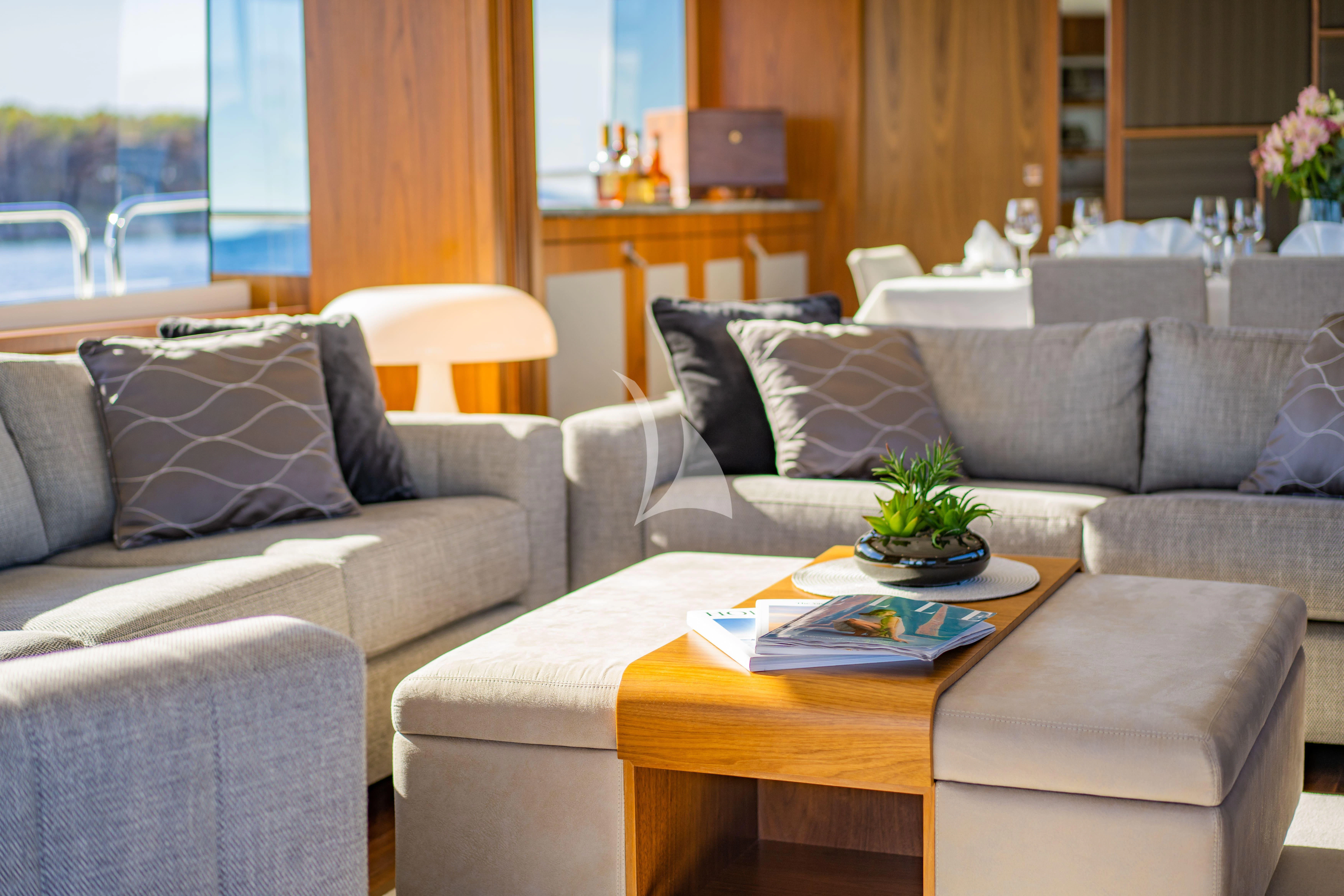 a living room with a couch and a coffee table aboard BLACK MAMBA Yacht for Charter