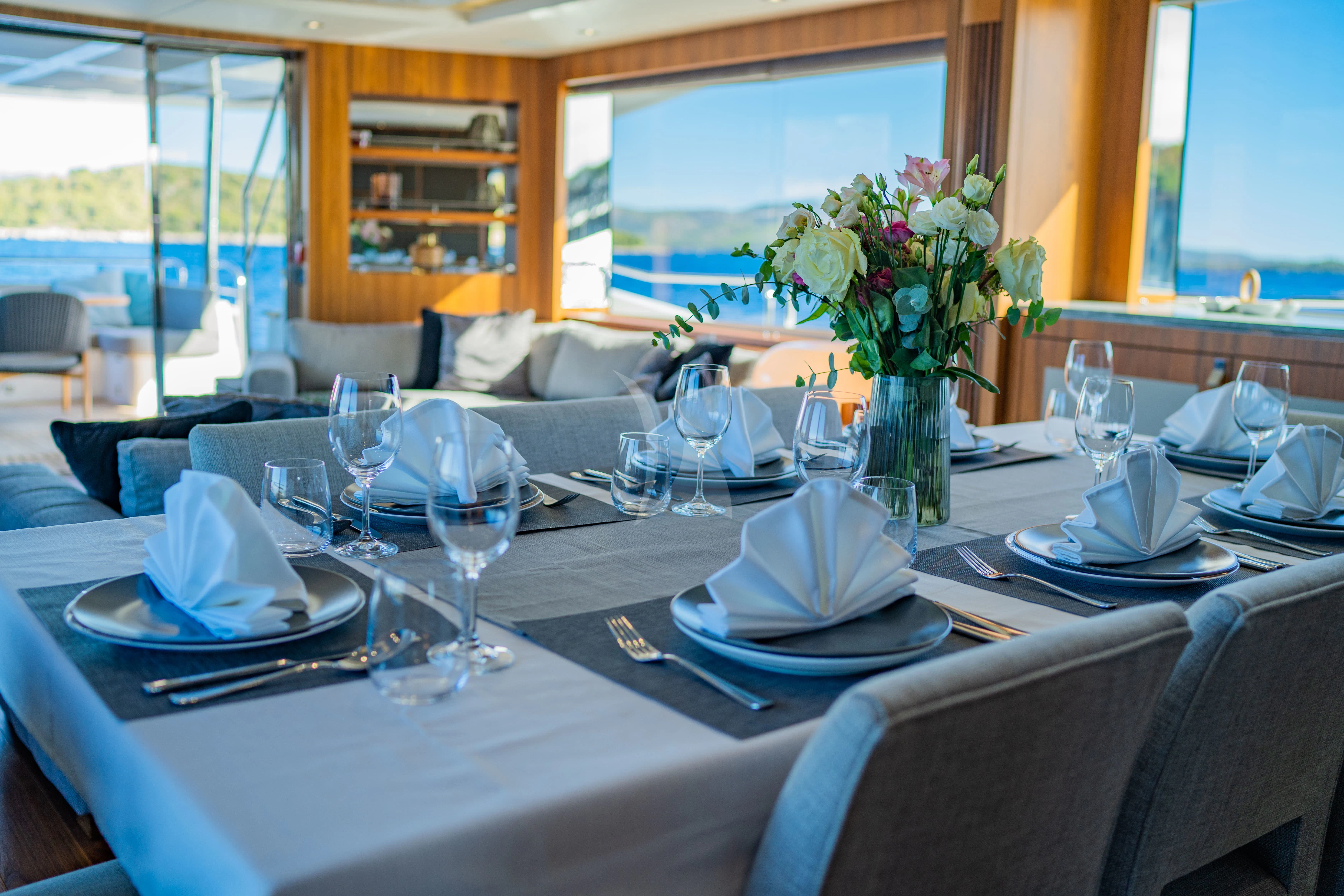 a table with plates and glasses aboard BLACK MAMBA Yacht for Charter