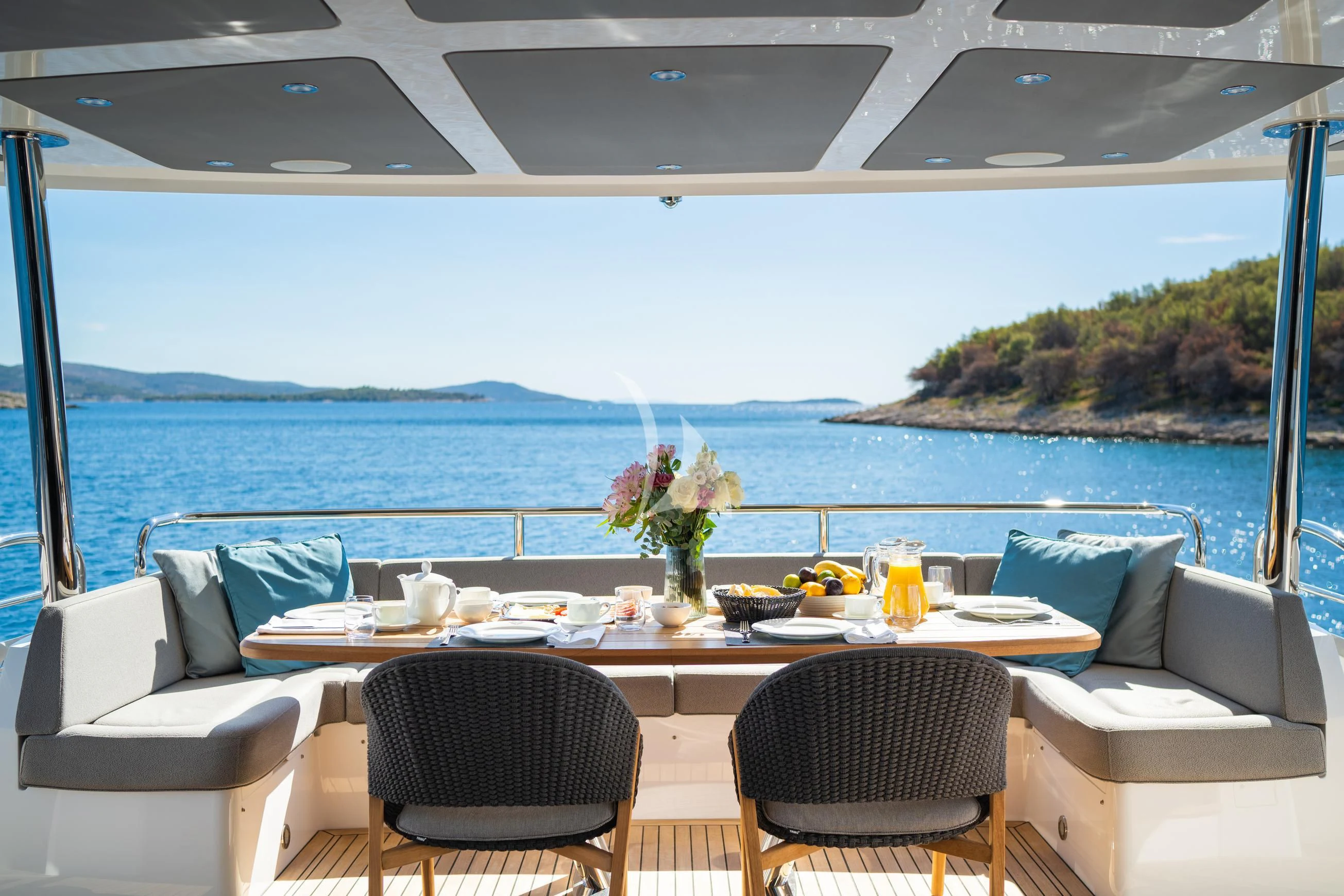 a table with chairs and a view of the ocean aboard BLACK MAMBA Yacht for Charter