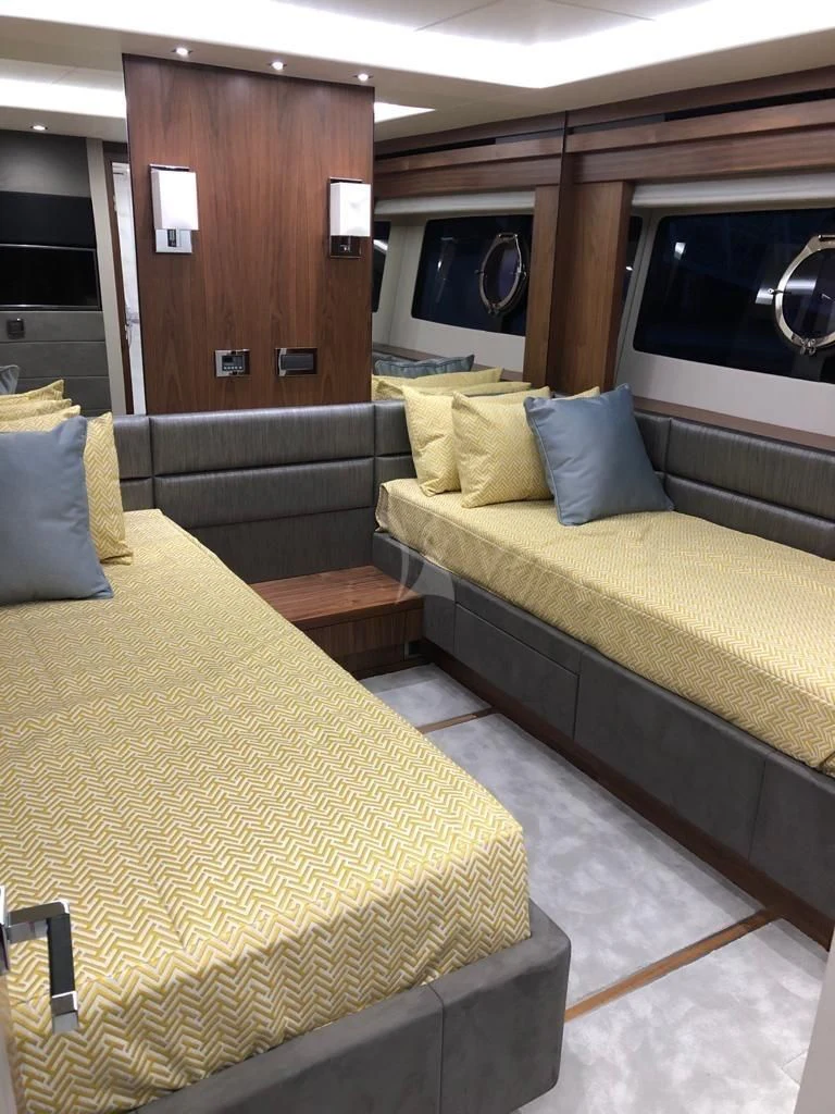 a room with a bed and a television aboard BLACK MAMBA Yacht for Charter