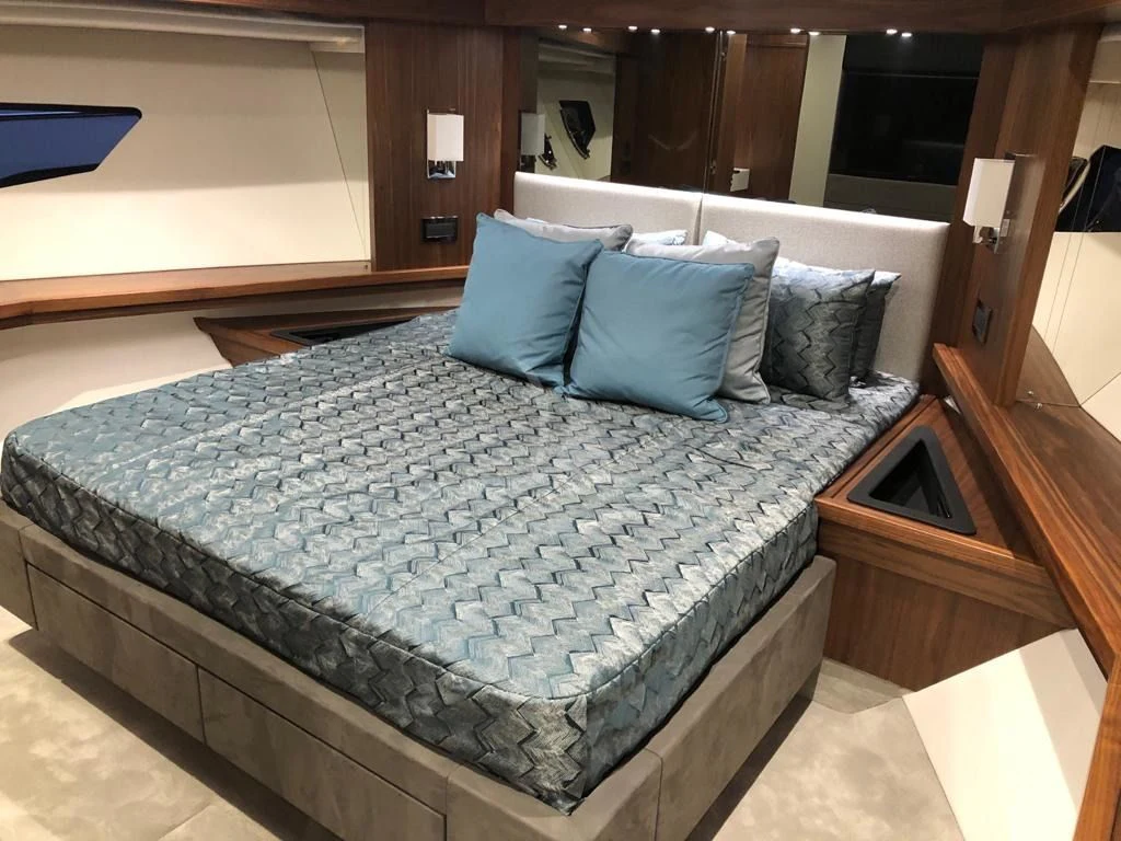 a bed with blue pillows aboard BLACK MAMBA Yacht for Charter