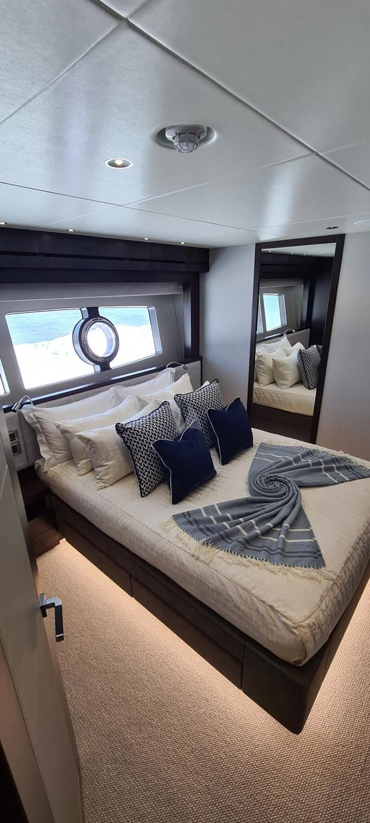 a bed with pillows and a window aboard MR K IRISTON Yacht for Sale