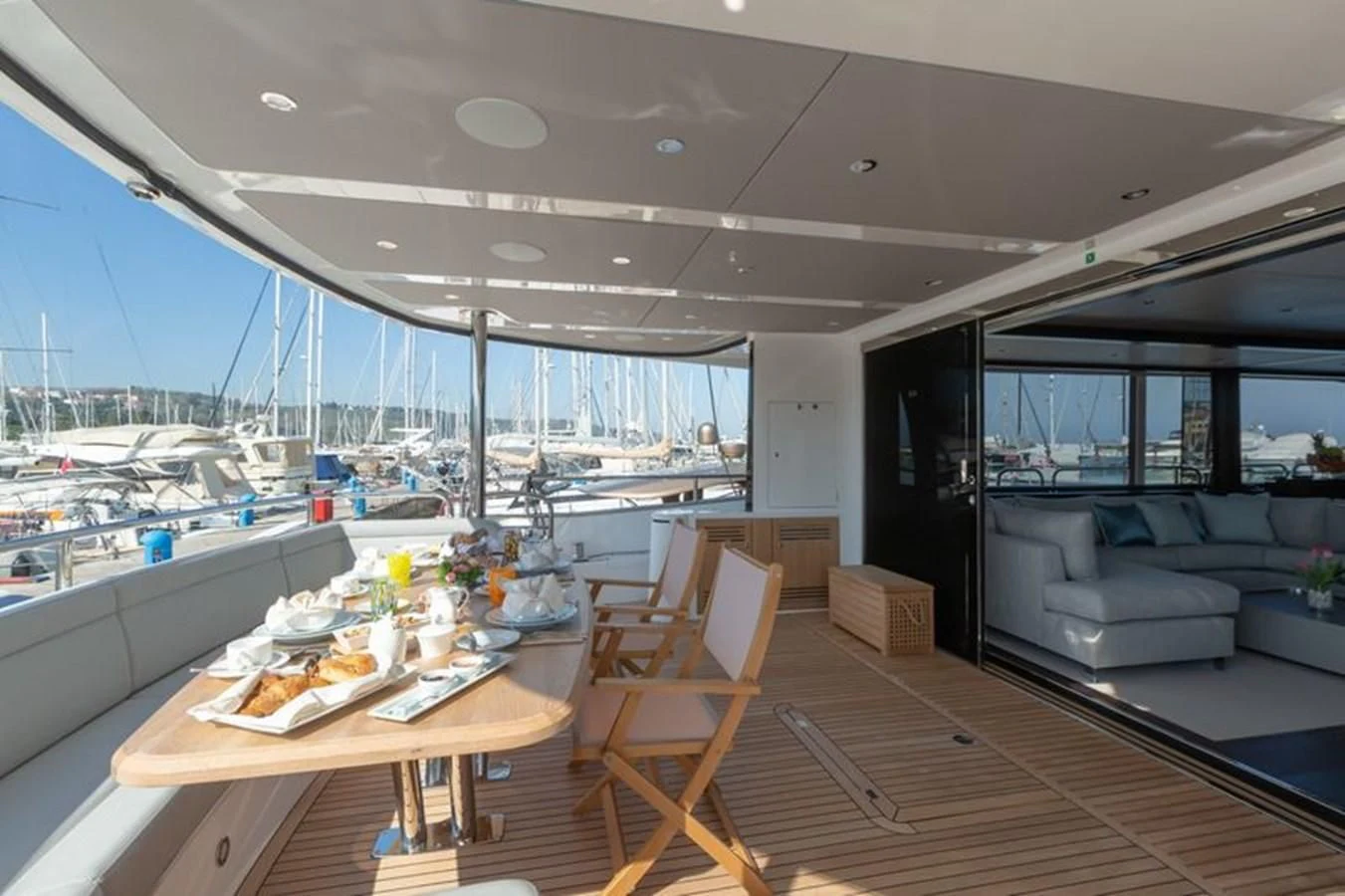 a modern looking living room with a wood table and chairs aboard MR K IRISTON Yacht for Sale