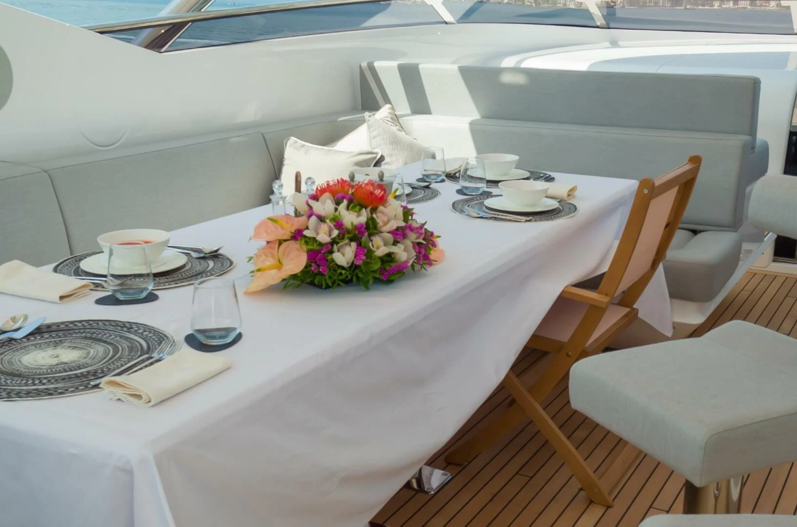 a table with a plate of food and flowers on it aboard MR K IRISTON Yacht for Sale