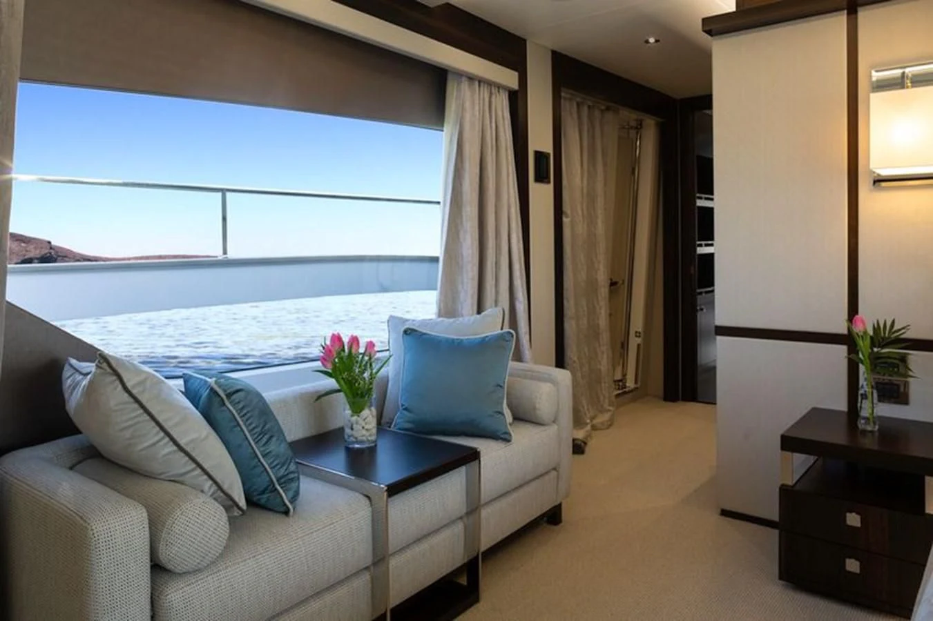 a living room with a large blue couch and a large window aboard MR K IRISTON Yacht for Sale