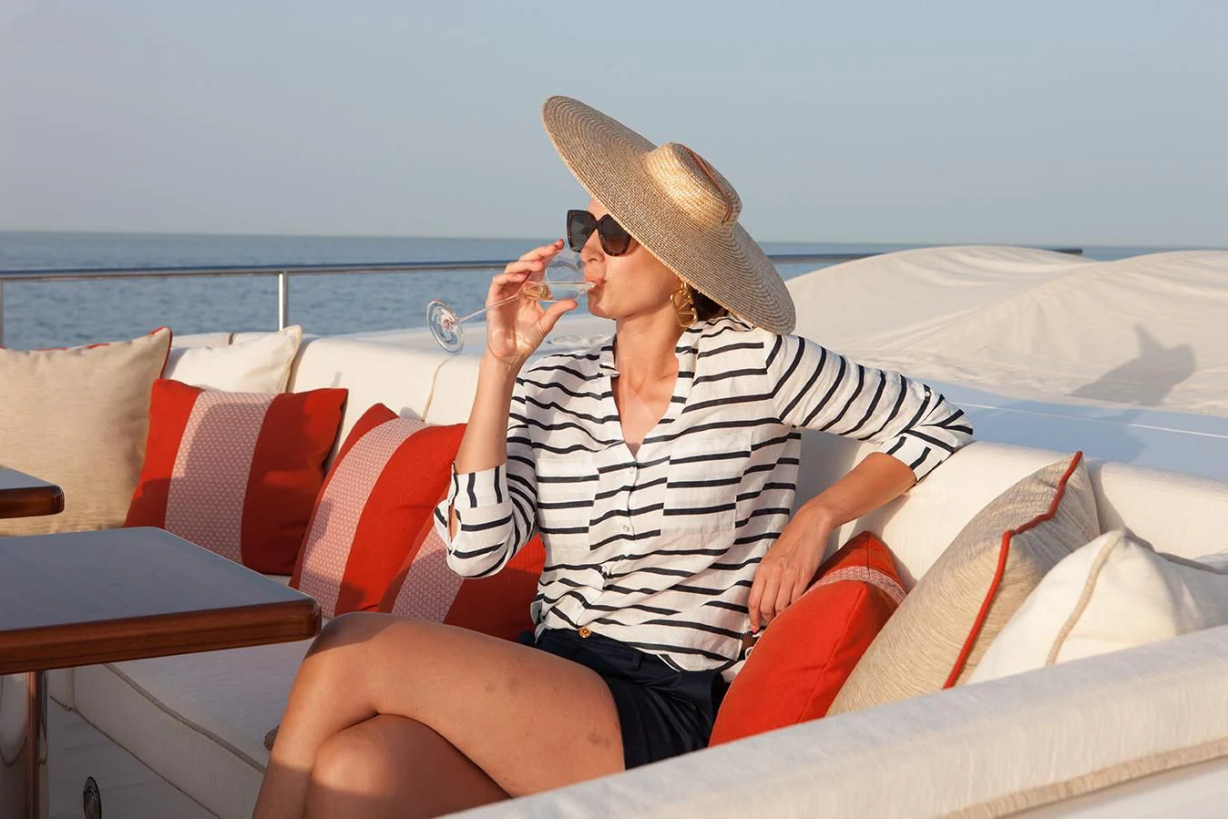 a person sitting on a bed drinking from a straw aboard DAISY D Yacht for Sale