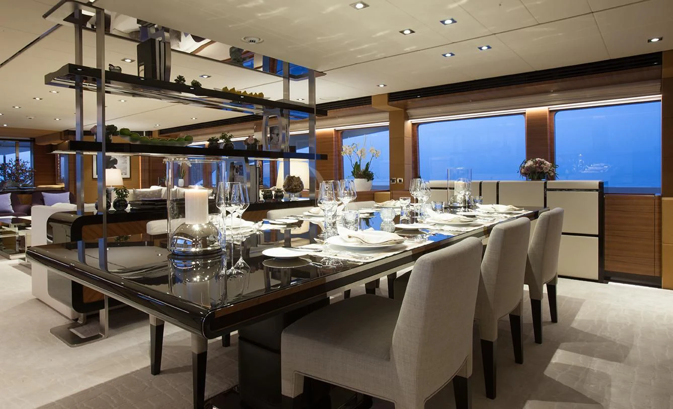 a large table with white chairs aboard DAISY D Yacht for Sale