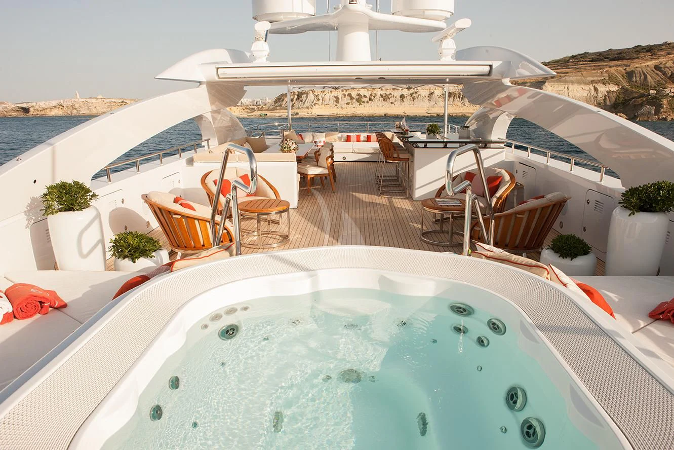 a large swimming pool with chairs around it aboard DAISY D Yacht for Sale