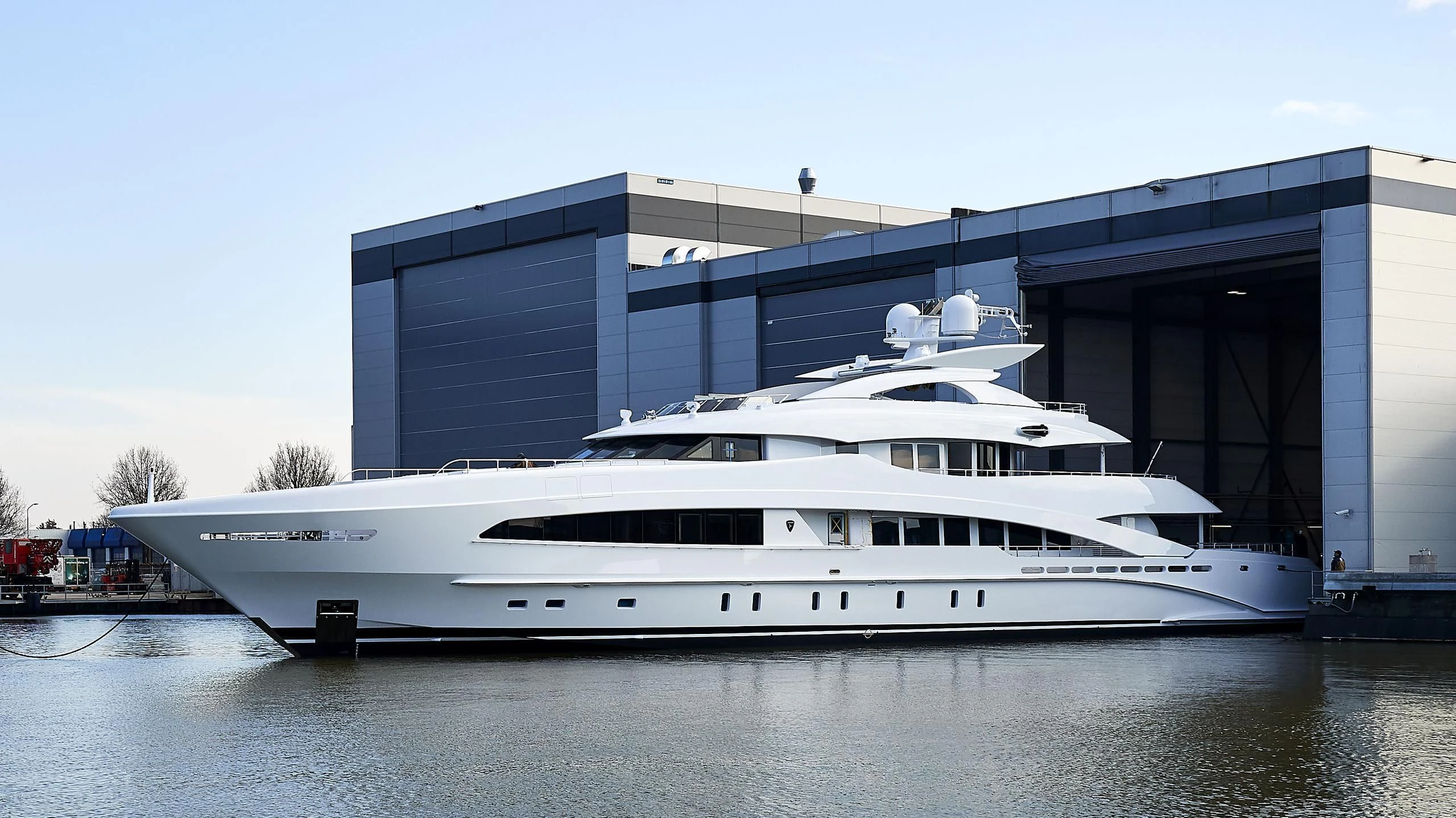 a large white yacht in front of a building aboard DAISY D Yacht for Sale