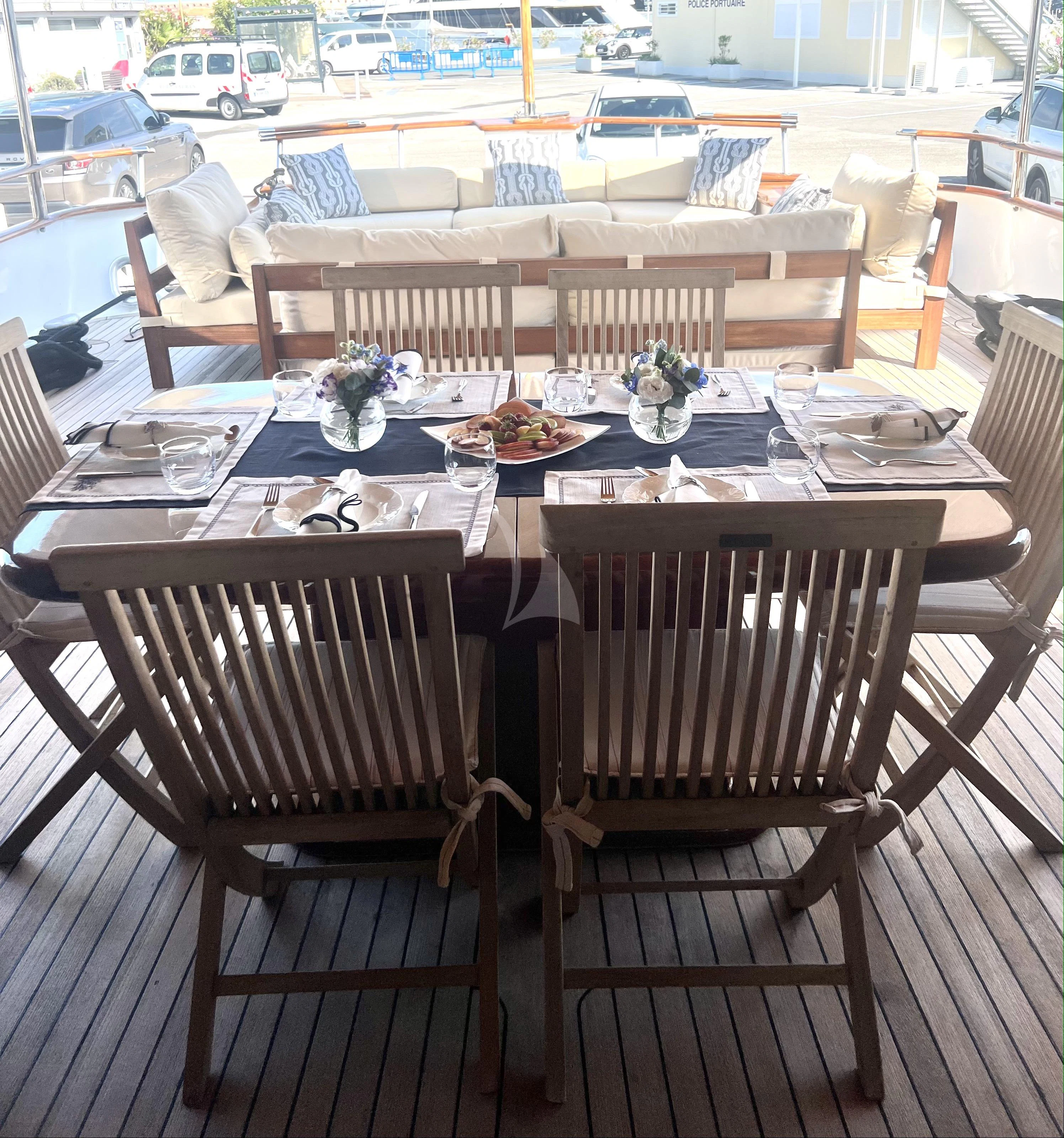 a table set with chairs and a table with food on it aboard ATLANTIC ENDEAVOUR Yacht for Charter