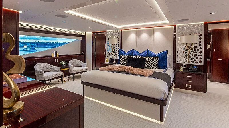 a bedroom with a bed and a large window aboard LION'S DEN Yacht for Sale