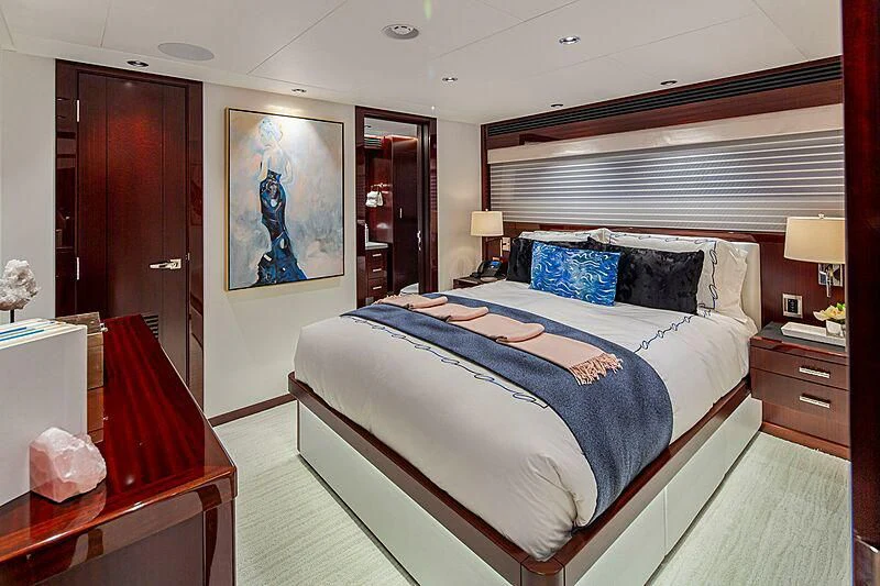 a bedroom with a bed and a desk aboard LION'S DEN Yacht for Sale
