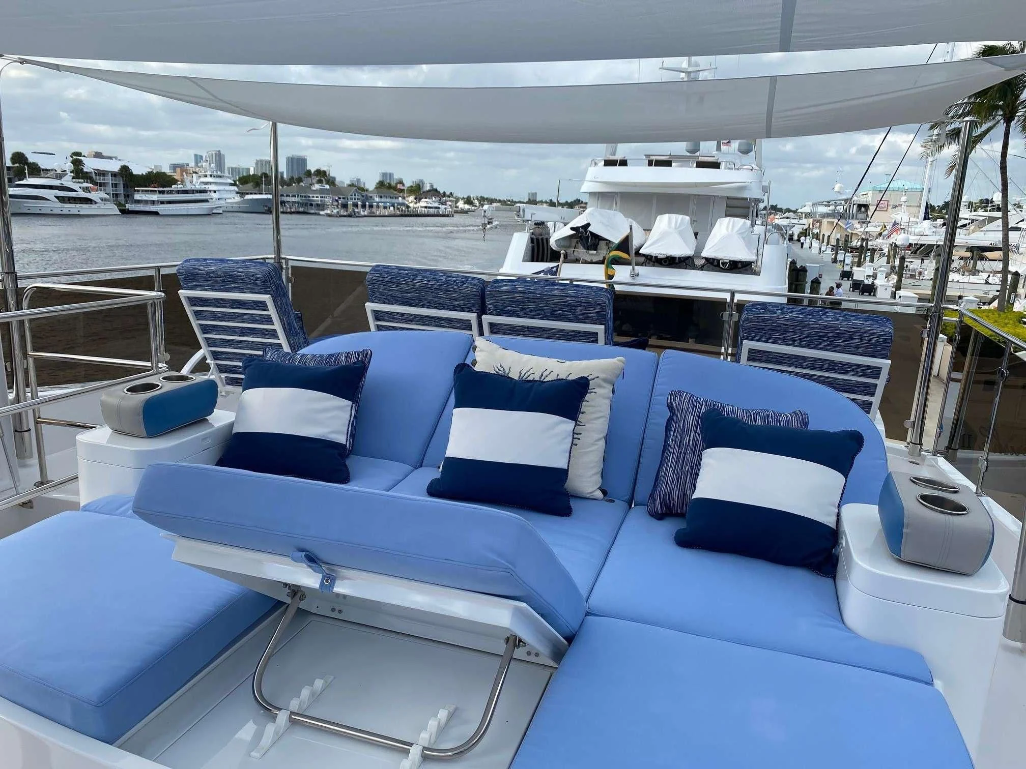 a lounge area with a large patio and a large building in the background aboard SLIPAWAY Yacht for Sale