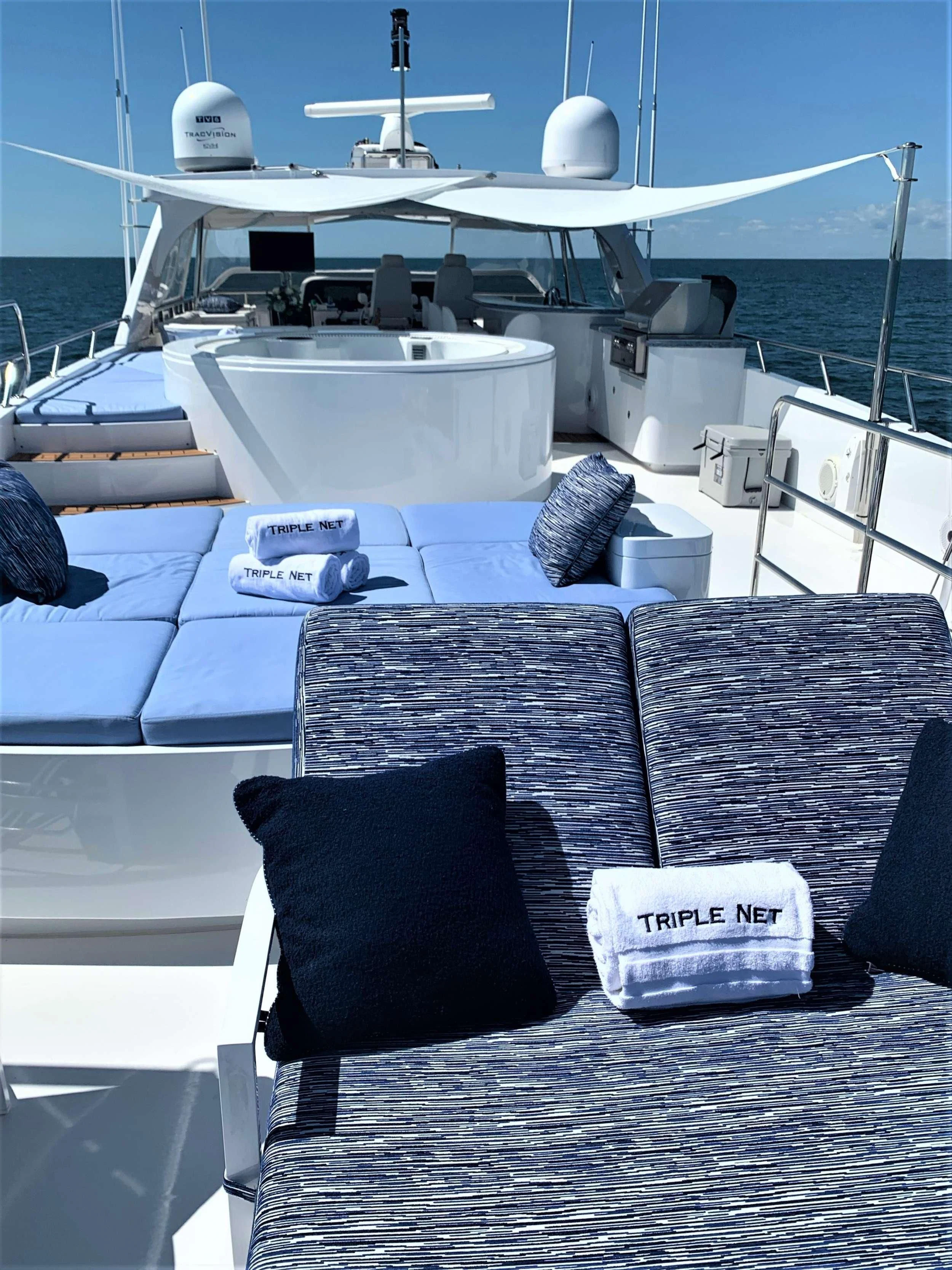 a table with chairs and a boat in the background aboard SLIPAWAY Yacht for Sale