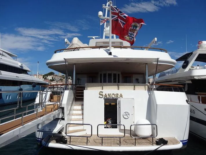 a large white boat with a flag on it aboard SANORA Yacht for Sale