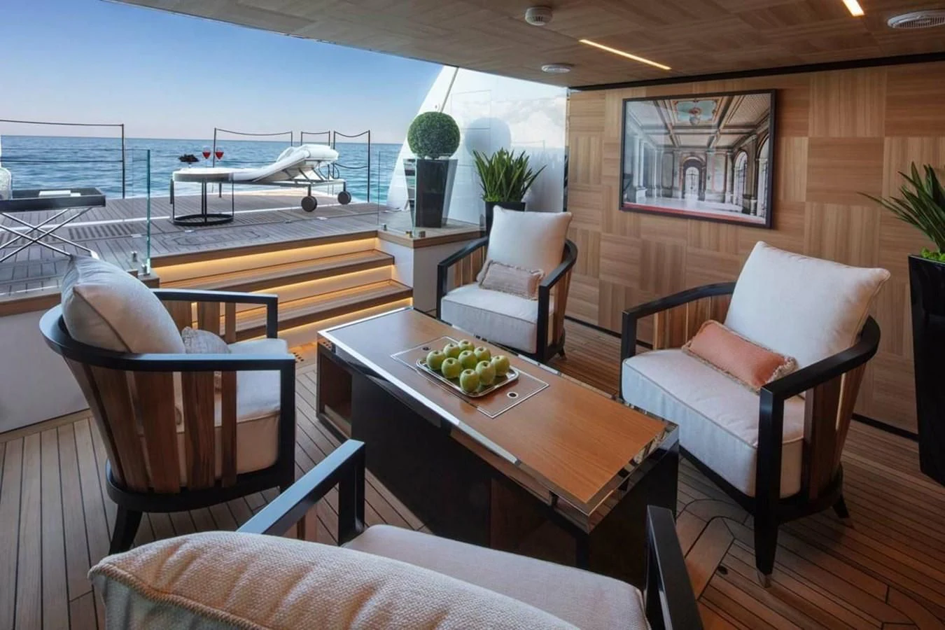a room with a table chairs and a boat in the water aboard AGORA III Yacht for Sale
