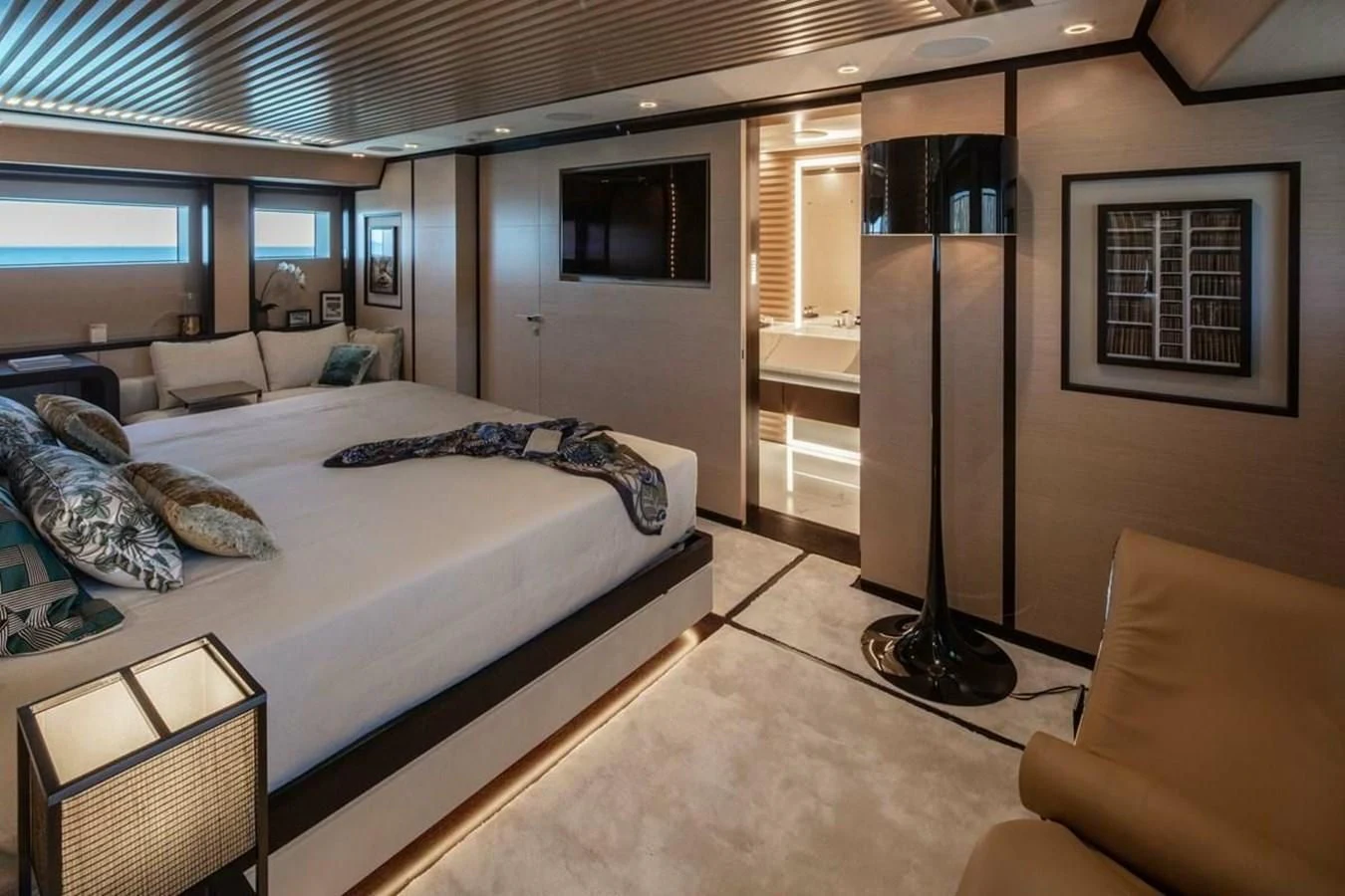 a bedroom with a bed and a lamp aboard AGORA III Yacht for Sale
