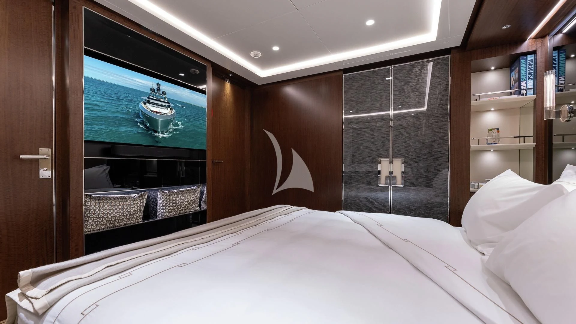 a bed with a television on the wall aboard ENTERPRISE Yacht for Charter