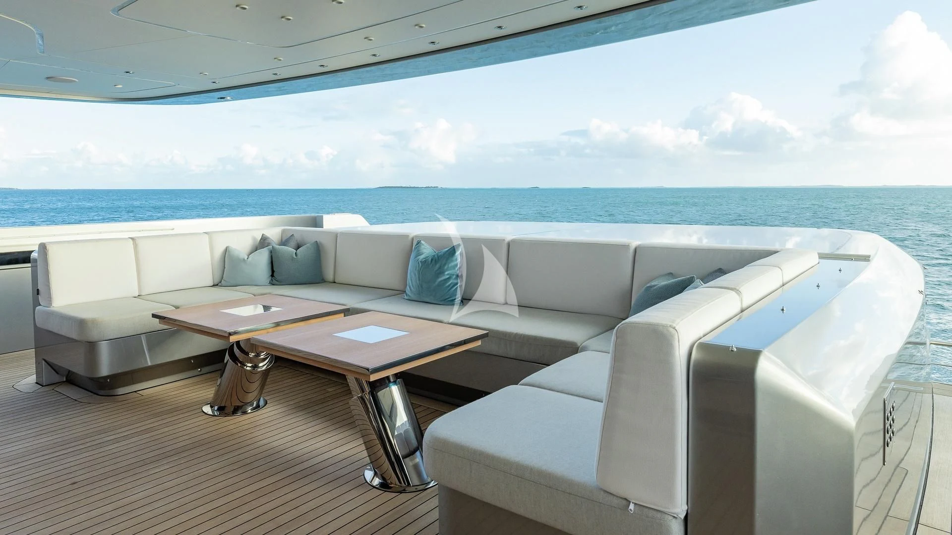 a white couch and a table on a deck overlooking the ocean aboard ENTERPRISE Yacht for Charter
