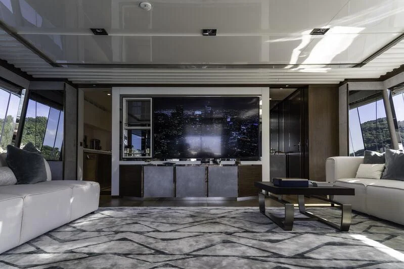a living room with a large tv aboard ENTERPRISE Yacht for Charter
