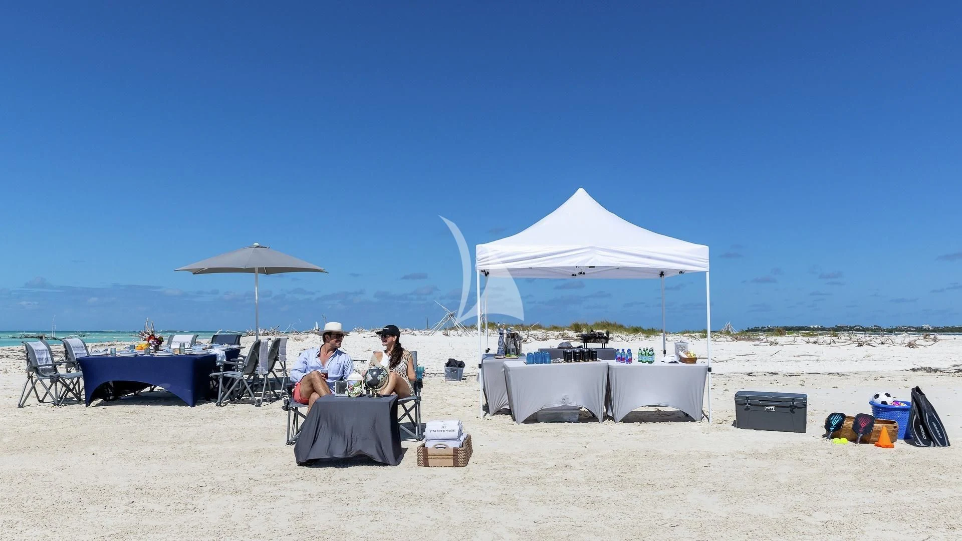 people sitting on a beach aboard ENTERPRISE Yacht for Charter