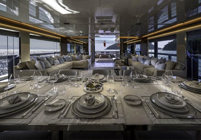a large table with plates and glasses aboard ENTERPRISE Yacht for Charter
