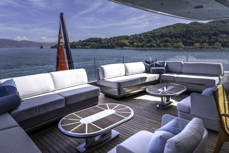 a living room with a large body of water and a boat in the background aboard ENTERPRISE Yacht for Charter